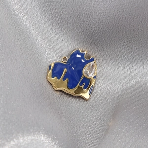 Golden heart pendant with deep blue enamel and sparkling droplet zircon on silk