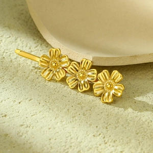 Macro detail of golden flower zircon hair clip on stone textured background