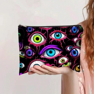 Detalle de neceser de lona con cremallera metálica y estampado de ojos de la suerte azul