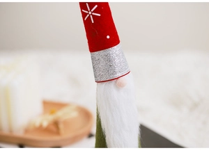Macro detail of Christmas gnome decoration showing red felt hat and white faux fur beard