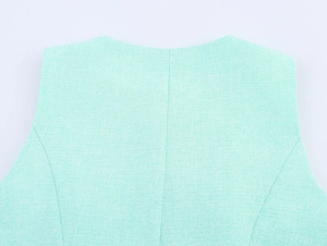 Gros plan du dos du gilet vert menthe montrant la texture tissée du tissu en tweed