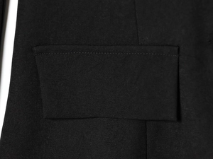 Close-up detail of pocket stitching and black twill fabric on women's slim fit blazer
