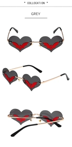 Detail of heart-shaped sunglasses with metal frame and central red bat wing motif