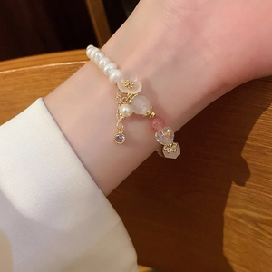 Detail of beaded flower bracelet with pearls and pink crystals on woman's wrist