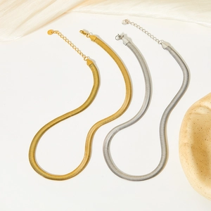 Minimalist gold and silver flat snake chain jewelry set on a clean white background