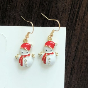 Detailed close-up of a Christmas snowman earring with red enamel and sparkling rhinestones
