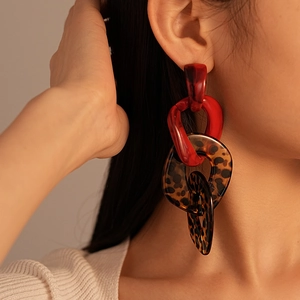 Close-up of red and leopard print acrylic interlocking link drop earrings on a model