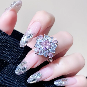 Close-up of a floral ring with a square pink gemstone and pear-shaped accents
