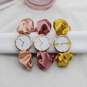 Close-up of elegant women's watches featuring colorful silk ribbon straps and rose gold cases