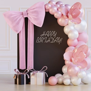 Detail of giant pink bow and balloon arch for birthday party wall backdrop decor