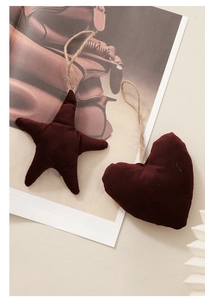 Dettaglio di decorazioni in velluto bordeaux a forma di stella e cuore con cordini