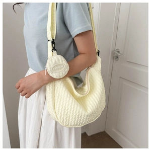 Detail of beige crescent crossbody bag with bubble texture and round coin purse