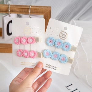 Detail of handmade embroidered flower hair clips in pink and blue for kids