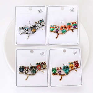 Detailed view of four owl brooches with colorful enamel and sparkling rhinestones