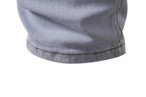 Macro shot of light blue denim fabric texture and orange double-stitched hem seams