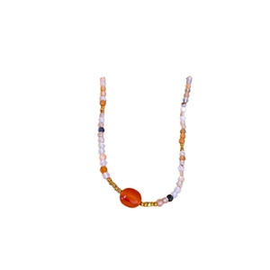 Bohemian beaded necklace with orange agate gemstone and gold plating on white background