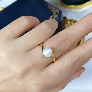 Elegant bypass ring with a single white freshwater pearl on a polished gold band