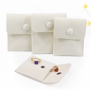 Macro detail of creamy white velvet jewelry pouches in three sizes with snap button closure