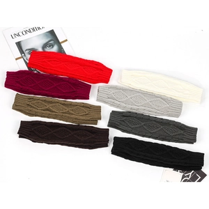Flat lay of diamond knit arm warmers in eight colors including red, beige, and grey