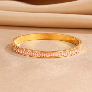 Close-up of golden stainless steel bangle with pink rectangular zircon stones