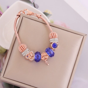 Detail of rose gold beaded bracelet with dark blue faceted glass beads and heart charms