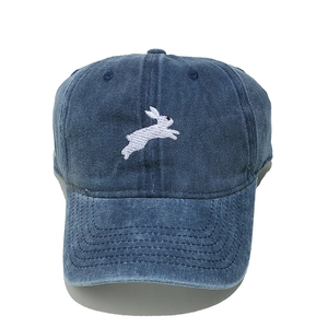 Detailed embroidery of a white rabbit on a dark blue washed denim baseball cap