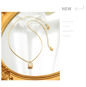 Détail de collier en titane plaqué or 18k avec pendentif carré en nacre blanche
