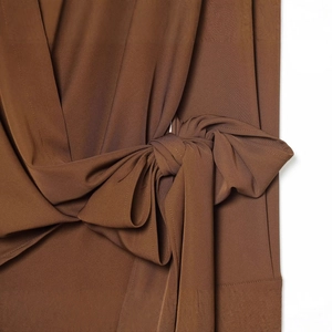 Haut plissé marron foncé avec détail de nœud sophistiqué et texture de tissu tissé