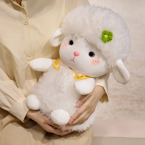 Soft white lamb plush toy with yellow lace collar and green flower detail held by a model