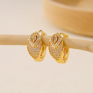 Detail of gold huggie earrings with double-layered pavé cubic zirconia on a wooden display
