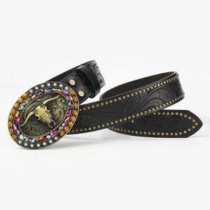 Detail of western belt buckle with bull skull, colorful beads and embossed leather