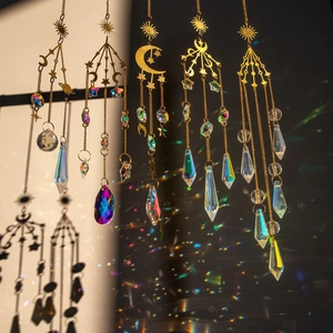 Golden galaxy crystal suncatchers with star and moon charms producing rainbow light