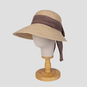 Détail de chapeau en raphia avec élégant ruban marron et texture paille raffinée