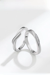 Detail of silver intertwining couple rings with micro-set zircons and adjustable band