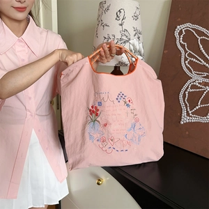 Détail du sac cabas en Oxford rose avec broderies colorées et anses en corde orange tressée