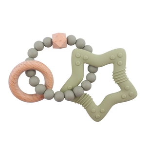 Detail of star-shaped silicone teether with natural wooden rings and sage green beads