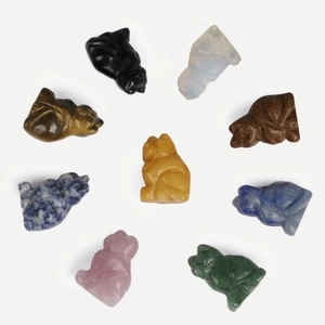 Hand-carved natural crystal animal figurines in various gemstones on a white background