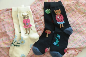 Detailed view of forest animal socks with cat, mushroom, and flower jacquard patterns