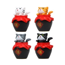 Close-up of four miniature cats peeping out of black sake jars for garden decor