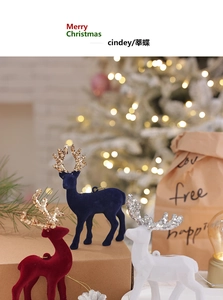 Close-up of flocking reindeer ornaments with glitter antlers in red, white and blue