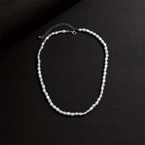 Detailed view of white pearl necklace with silver metal extension chain and lobster clasp
