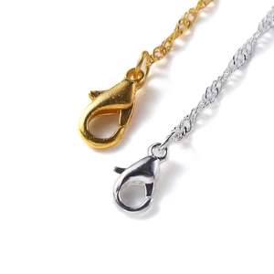 Macro shot of gold and silver lobster clasps with metal chain links for jewelry making