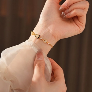 Elegant gold plated heart bracelet with pearl and pavé diamonds on a model's wrist