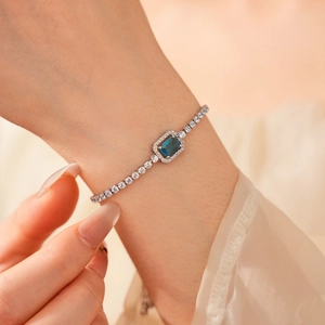 Close-up of adjustable silver bracelet with square blue gemstone and sparkling zircons