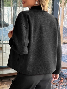 Dettaglio del gilet grigio scuro con zip, colletto alla coreana e morbida lana sintetica