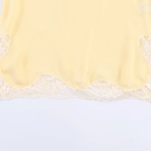 Pale yellow lace-trimmed top featuring delicate floral embroidery and premium fabric