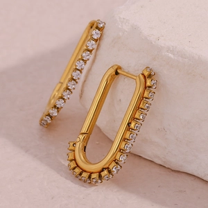 Close-up of gold-plated U-shaped earrings featuring a vertical row of clear cubic zirconia