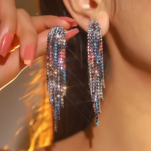 Detailed view of luxury long tassel earrings with sparkling colorful rhinestones on model