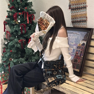 Chic winter outfit featuring an off-shoulder sweater and a plush crossbody bucket bag