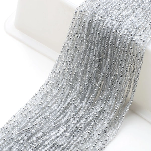 Close-up of silver faceted glass beads on cotton thread for DIY jewelry making